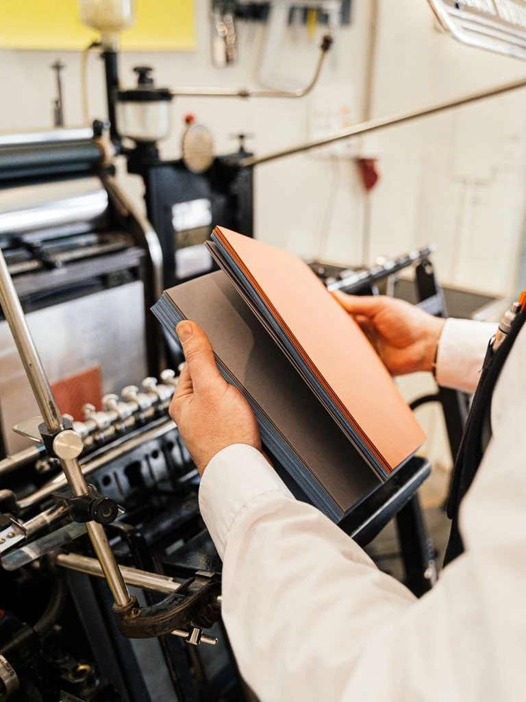 Master printer's hands holding a freshly printed archival photograph