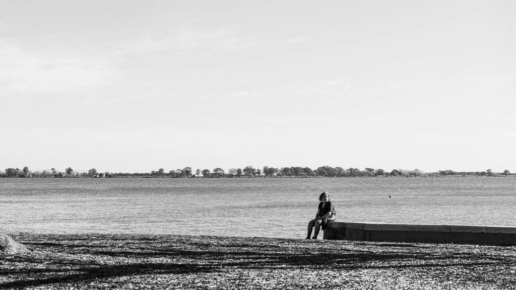 Archival pigment print of a solitary figure walking a foggy shoreline at dawn